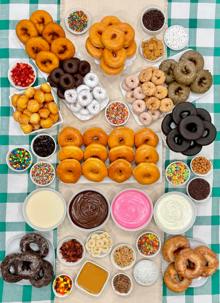 Colorful assorted donuts with vibrant toppings on checkered tablecloth fun dessert wallpaper