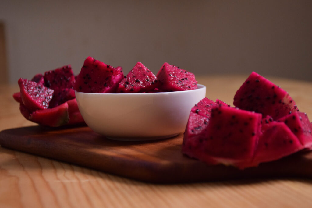 Vibrant Dragonfruit Wallpaper: Fresh Chunks on Wood & White Bowl