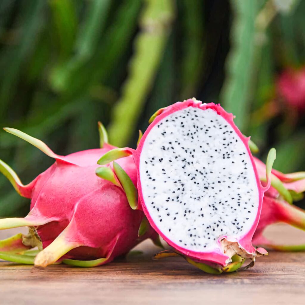 Vibrant dragonfruit wallpaper showing pink skin and speckled white interior with green background
