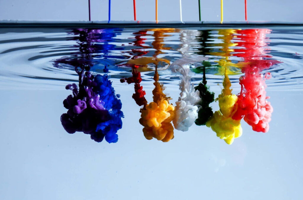 Vibrant Dye Plumes in Clear Water: Mesmerizing Wallpaper Background