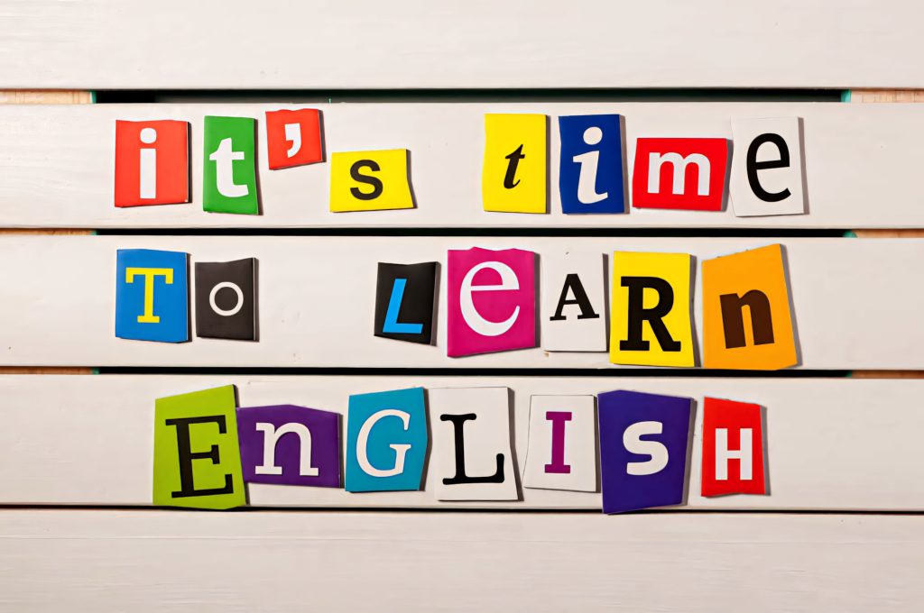 Vibrant educational wallpaper with colorful cut-out letters spelling its time to learn English on white wood background