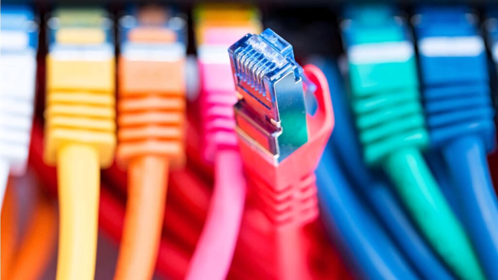 Close-up of vibrant colorful Ethernet network cables with red cable in sharp focus high-speed connectivity Wallpaper