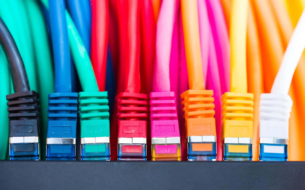 Colorful Ethernet cables plugged into a network switch showing modern connectivity technology background Wallpaper