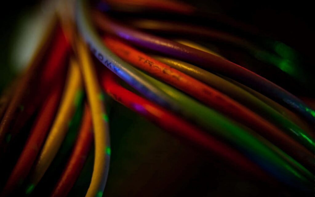 Close-up of colorful Ethernet cables in red yellow and green on dark tech background wallpaper