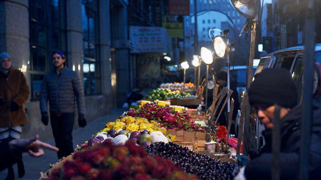 Vibrant Evening Market: Fresh Fruits Under Bright Lights - Wallpaper