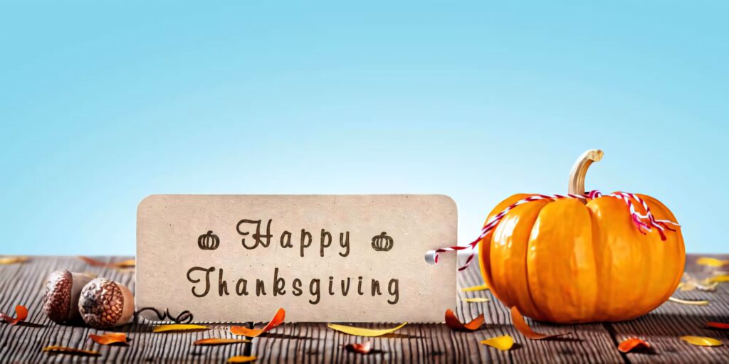 Vibrant fall Thanksgiving wallpaper with large pumpkin autumn leaves acorns Happy Thanksgiving sign