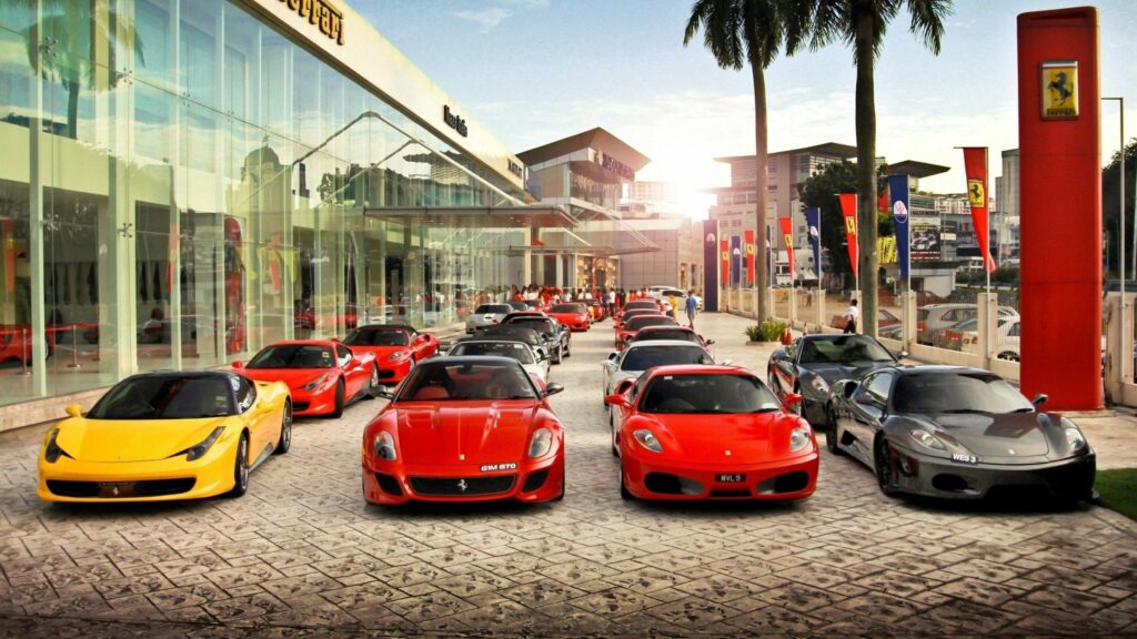 Luxury Ferrari Lineup Against Modern Urban Backdrop Wallpaper