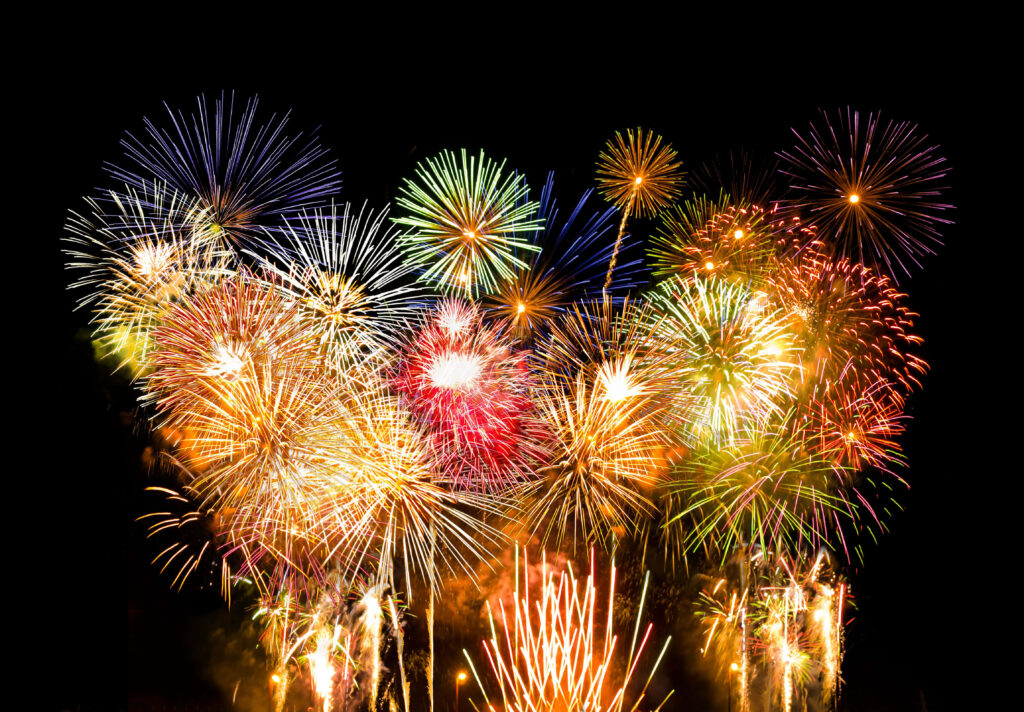 Vibrant colorful fireworks bursting in dark night sky festive energy wallpaper background