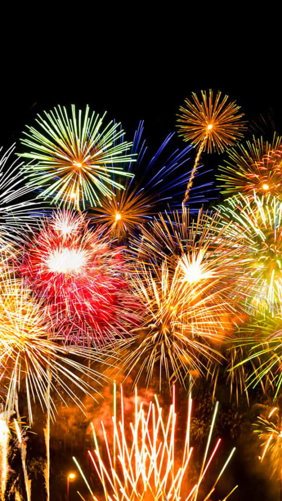 Colorful fireworks bursting in night sky vibrant festive celebration wallpaper background image