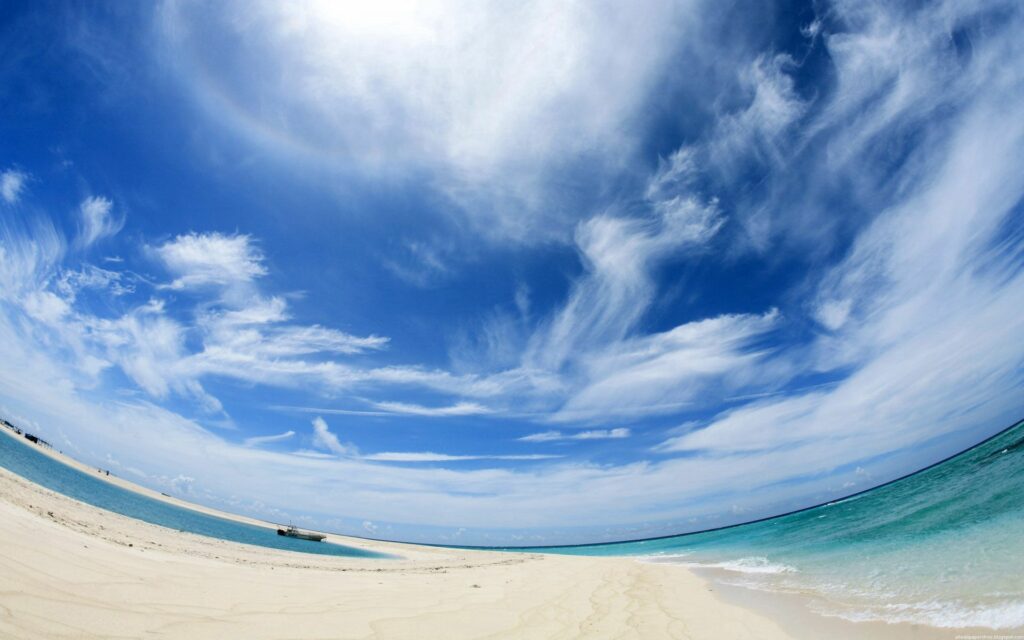 Fisheye beach wallpaper with white sand turquoise waters swirling cloud sky and distant ship