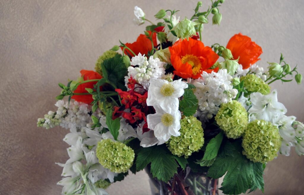 Vibrant Floral Arrangement: Daffodils & Lilacs in Glass Vase Wallpaper