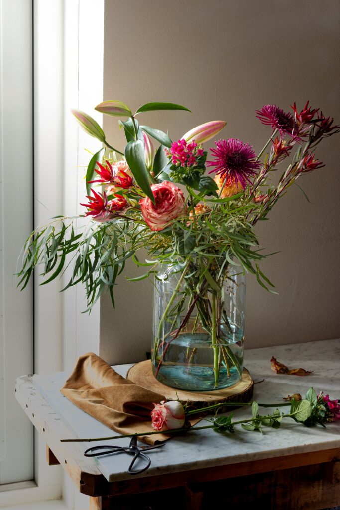 Vibrant Bouquet of Flowers in Glass Vase – Rustic Tabletop Background Wallpaper