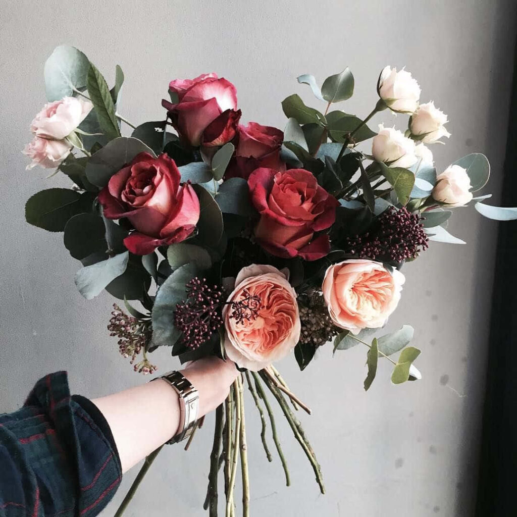 Vibrant Floral Wallpaper: Roses & Leaves in Red, Pink, Peach Tones