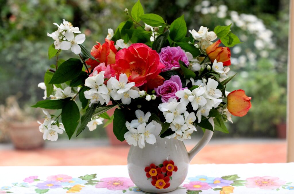 Vibrant Floral Wallpaper: Roses & Jasmine in Decorative Pitcher