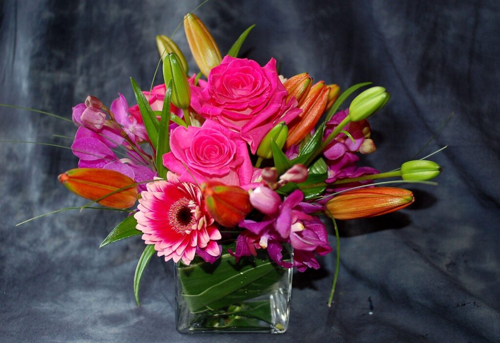 Vibrant Floral Arrangement in Glass Vase on Dark Background Wallpaper
