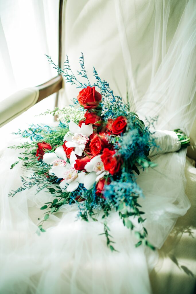 Vibrant Floral Wallpaper: Red Roses & Blue Accents on Sheer Background
