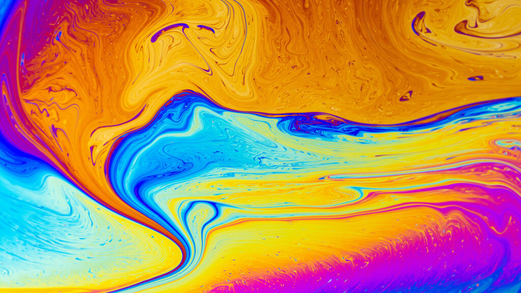 Abstract 4K wallpaper of swirling iridescent soap film with vibrant orange blue and magenta colors
