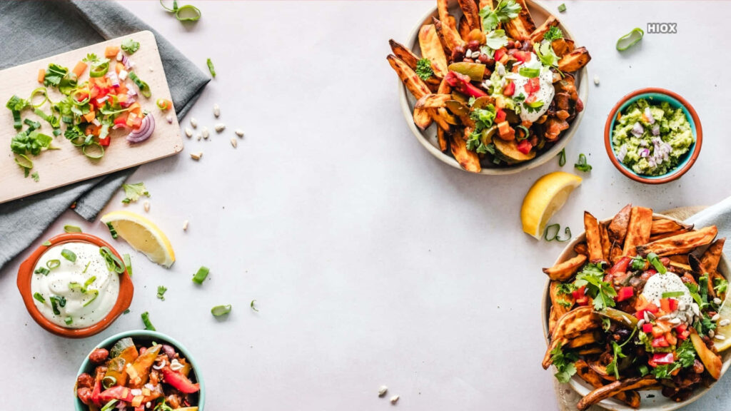Vibrant Food Table: Crispy Fries, Dips & Fresh Garnishes Wallpaper