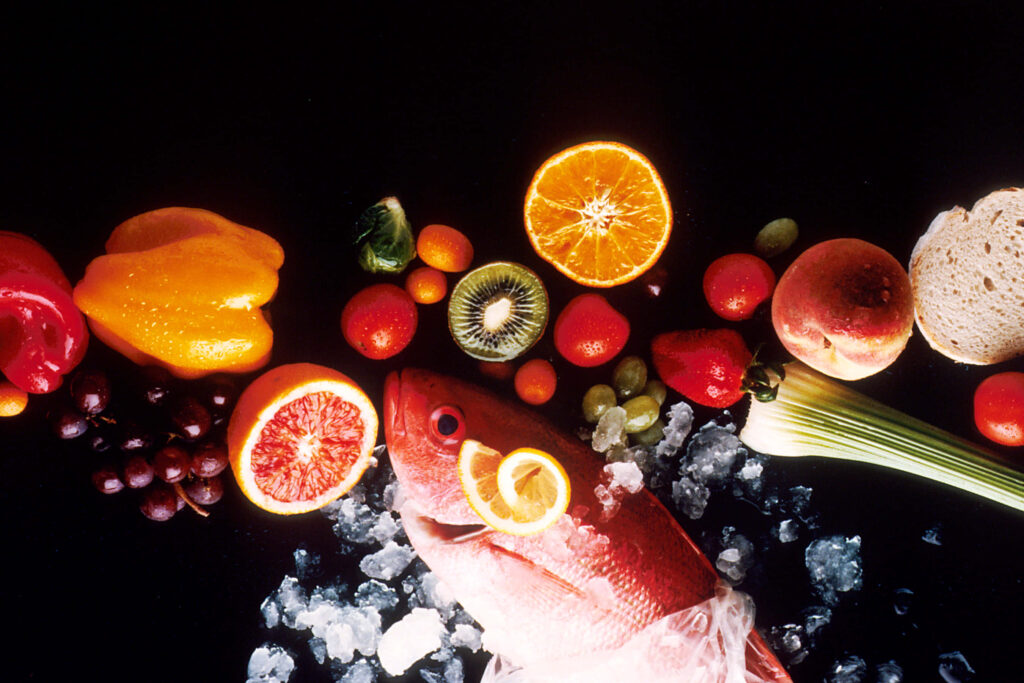 Vibrant Fresh Fish on Ice with Colorful Fruits & Veggies Wallpaper