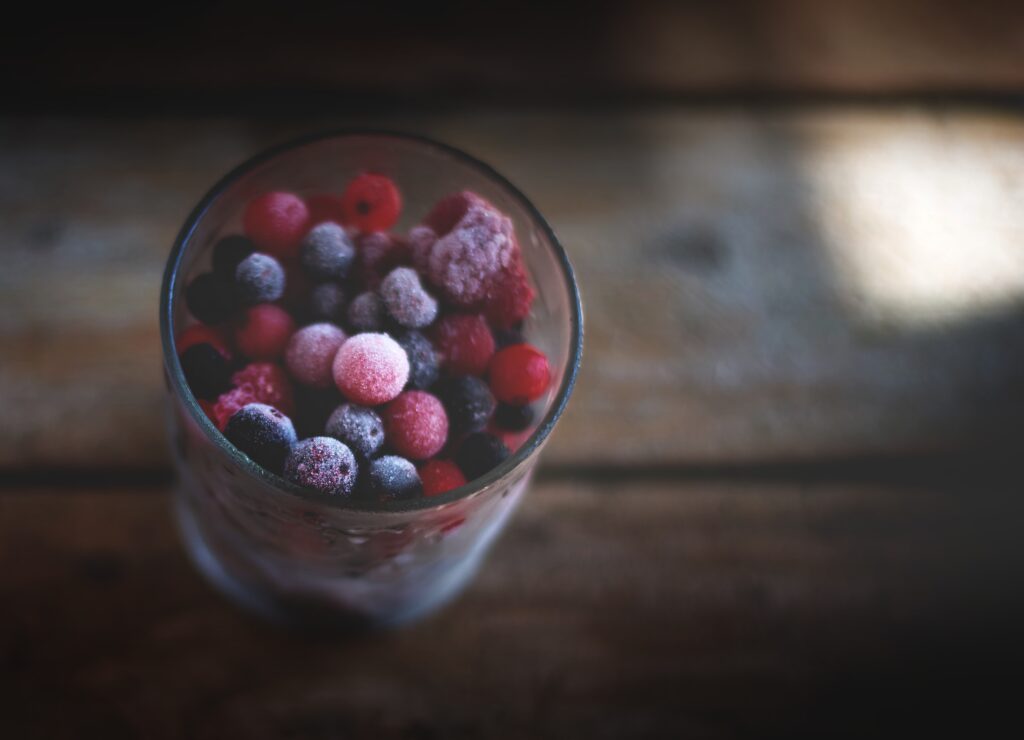 Vibrant Berry Mix in Chilled Glass | Rustic Wooden Wallpaper