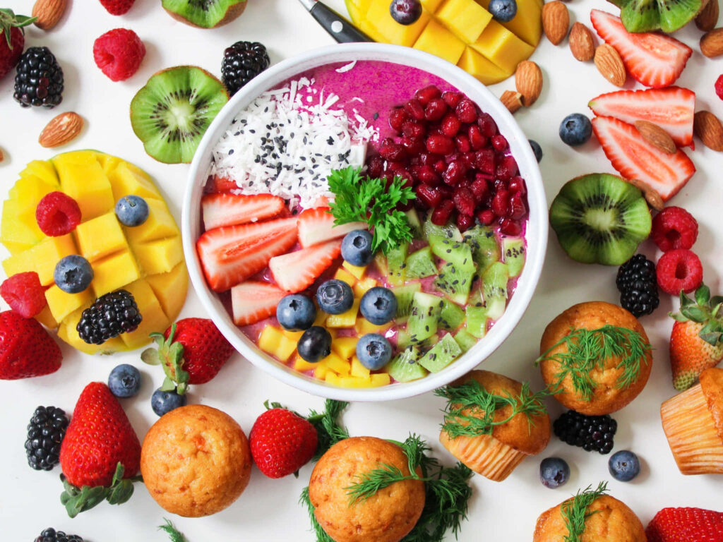 Vibrant Fruit Bowl Wallpaper: Fresh Fruits & Muffins Design