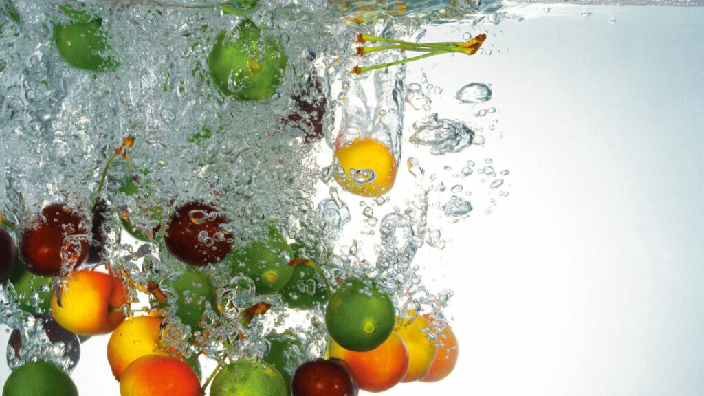 Vibrant Fruit Splash Wallpaper: Colorful Water Background Design