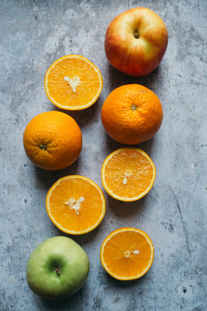 Vibrant Fruit Wallpaper: Fresh Oranges & Apples on Textured Background