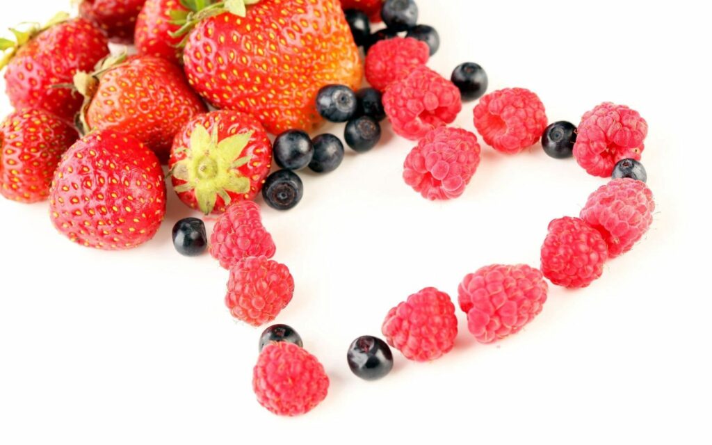 Vibrant Berry Wallpaper: Heart-Shaped Raspberries on White Background