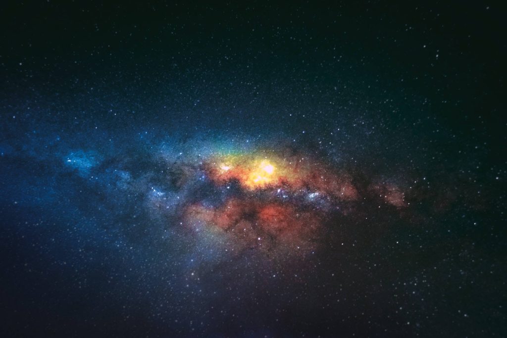 Vibrant galactic core with glowing nebula clouds and dense starfield in deep space wallpaper