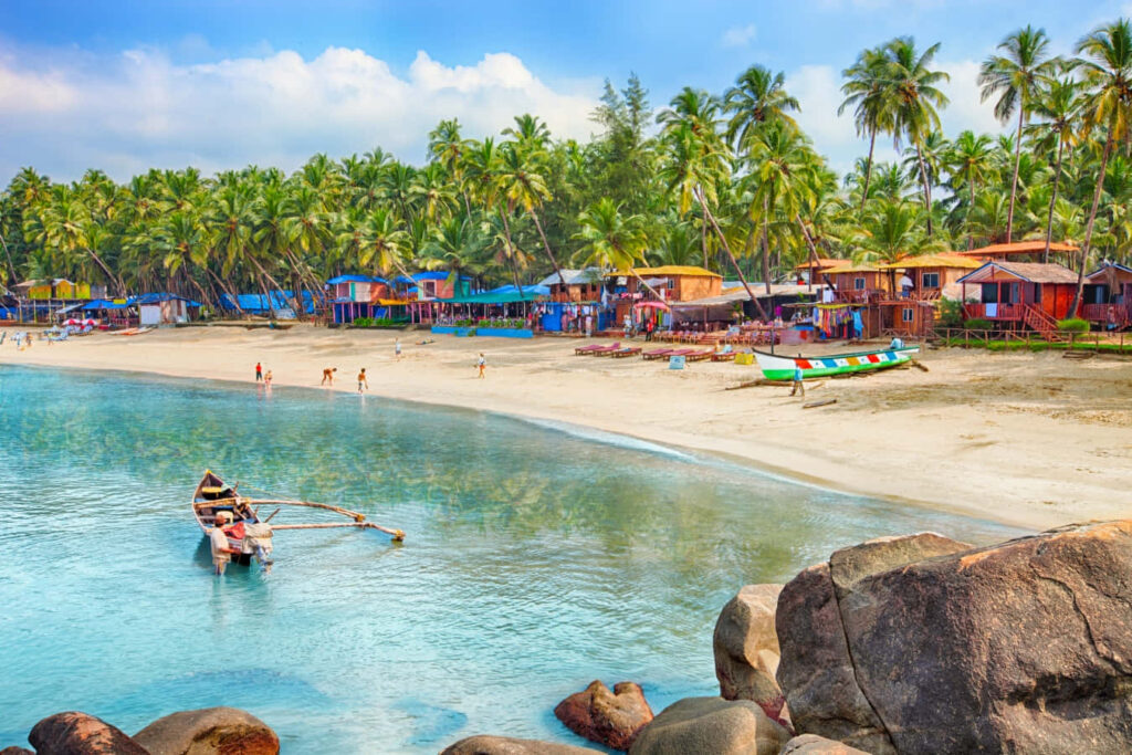 Serene Goan Beach Wallpaper: Clear Waters & Vibrant Huts Background