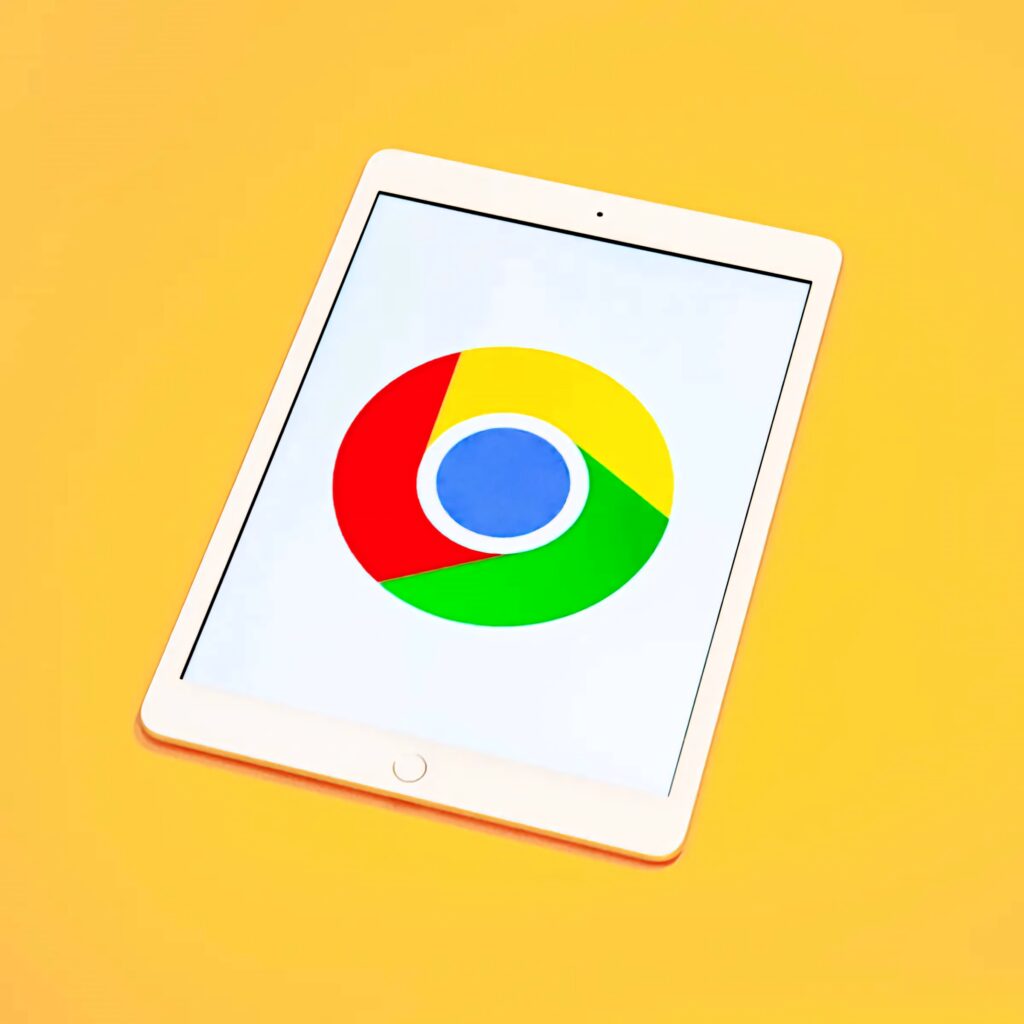 Tablet showing vibrant Google Chrome logo on yellow background bright tech wallpaper design