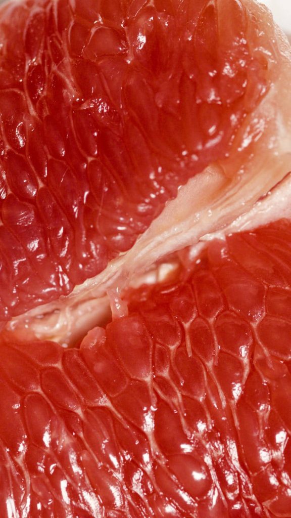 Close-up of vibrant pink grapefruit pulp with juicy texture high-definition citrus background Wallpaper