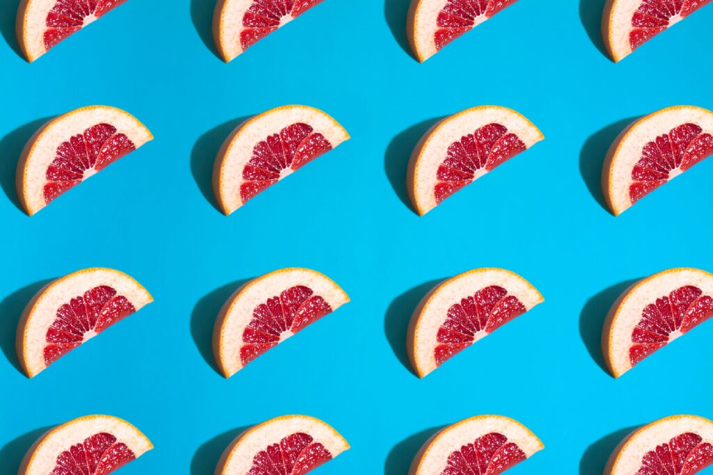 Fresh Grapefruit Wallpaper: Colorful Slice Pattern on Blue Background