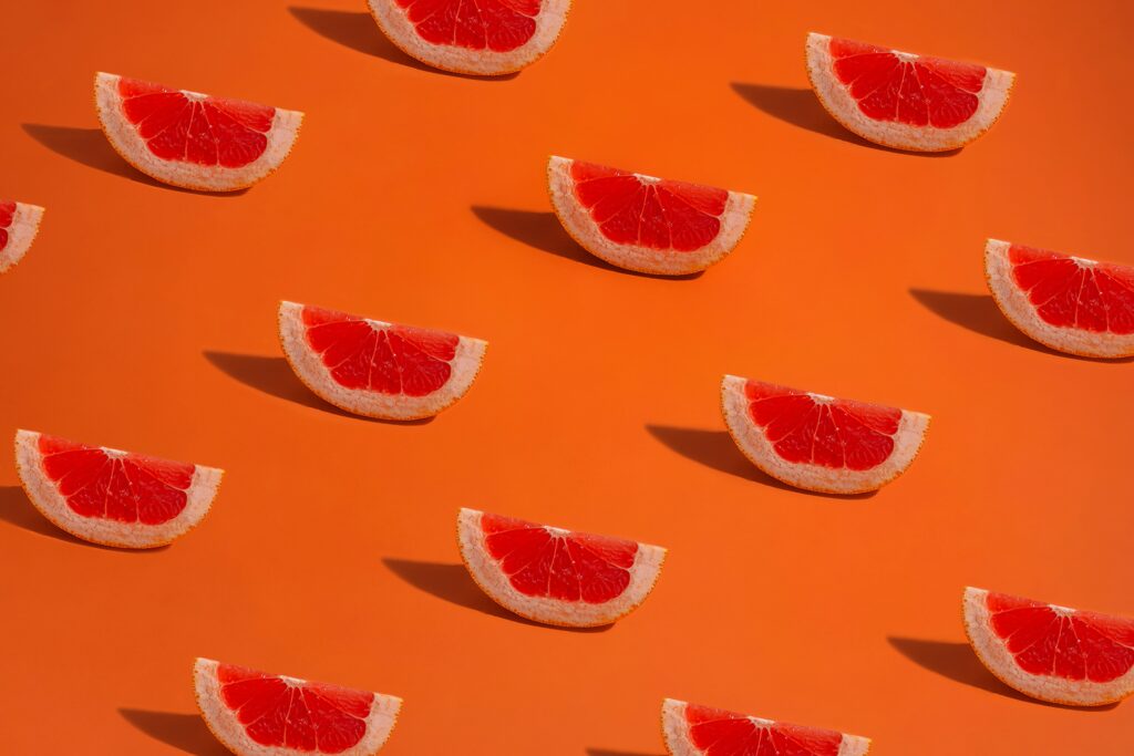 Vibrant Grapefruit Slice Wallpaper on Energetic Orange Background