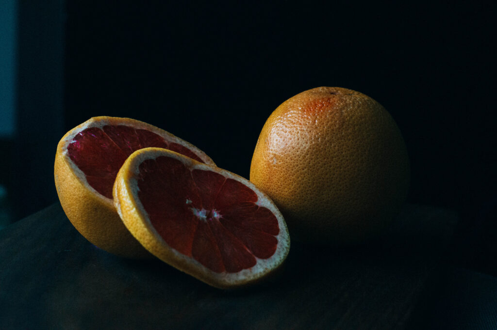 Vibrant Grapefruit Wallpaper: Freshly Sliced on Dark Background