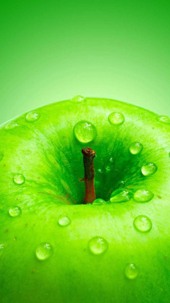 Macro close-up of vibrant green apple with water droplets on bright crisp background wallpaper
