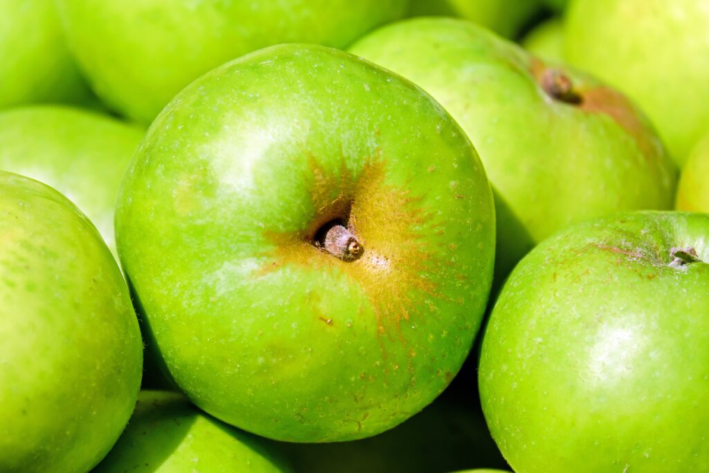 Vibrant Green Apple Wallpaper: Glossy Texture Background Design