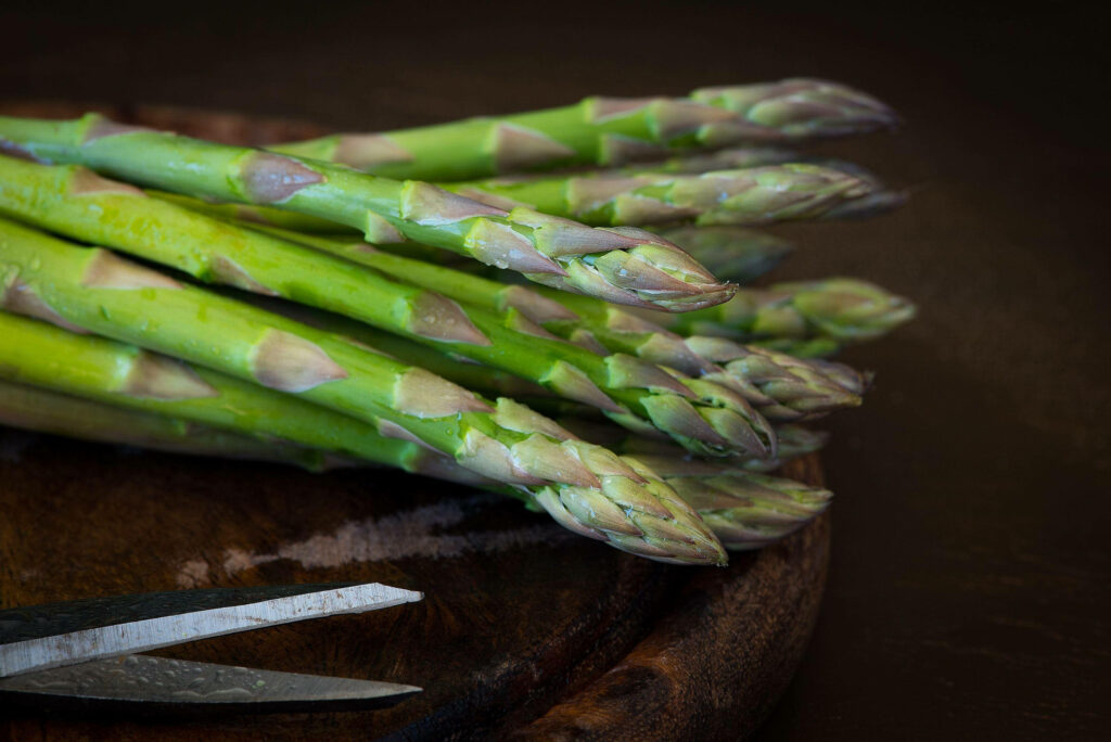 Vibrant Green Asparagus Wallpaper: Earthy Close-Up on Wood