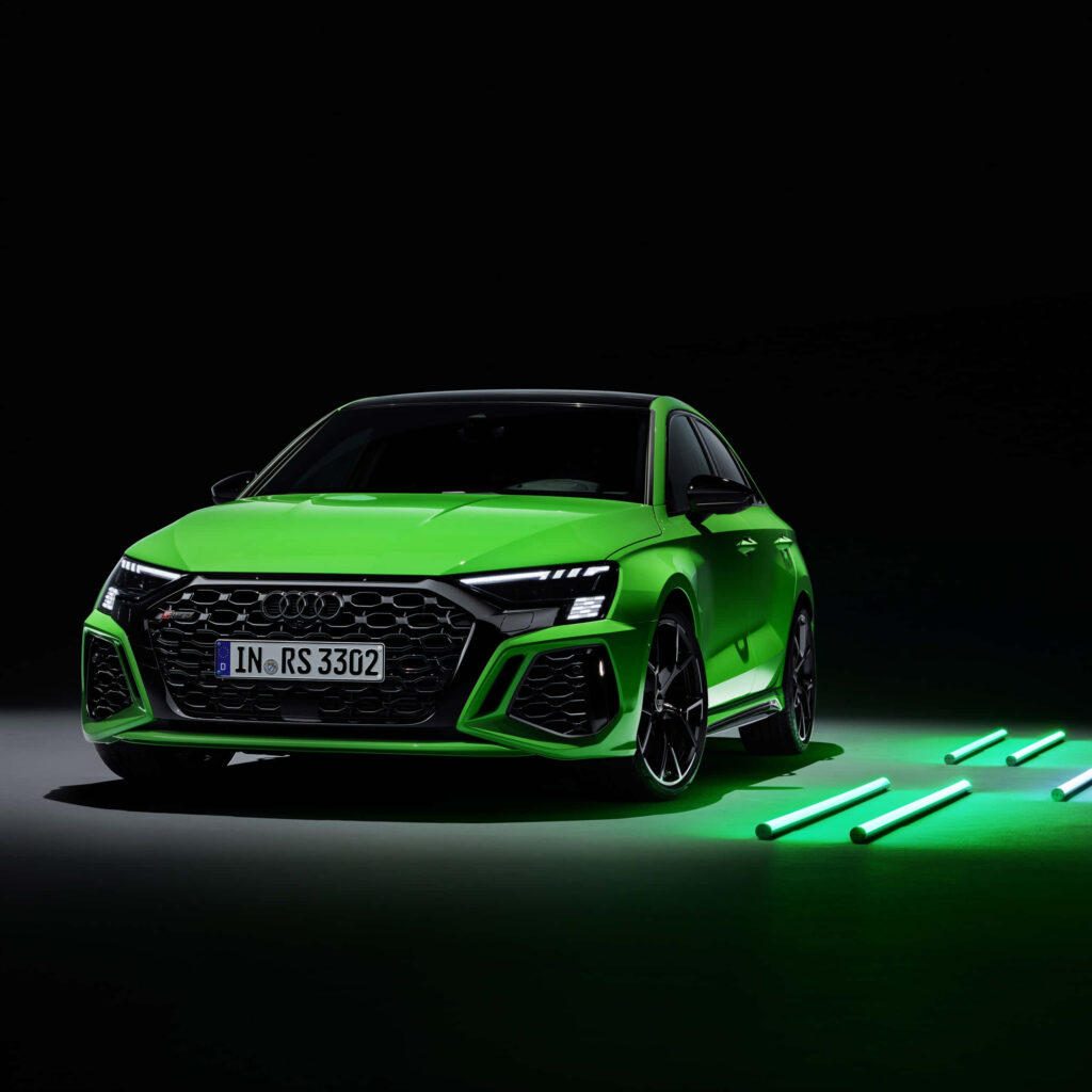 Vibrant green Audi RS sports car under dramatic lighting sleek modern design dark background wallpaper