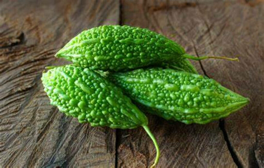 Vibrant Green Bitter Gourds Wallpaper on Rustic Wood Background