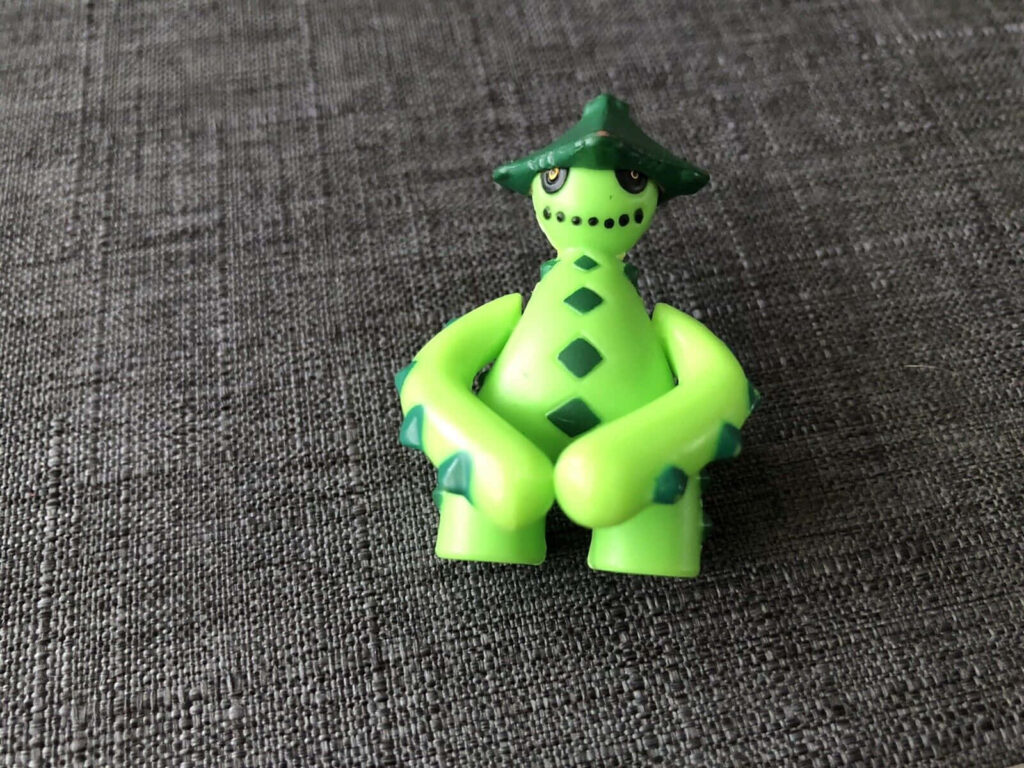 Vibrant Green Cacturne Toy Model Against Textured Gray Background Wallpaper