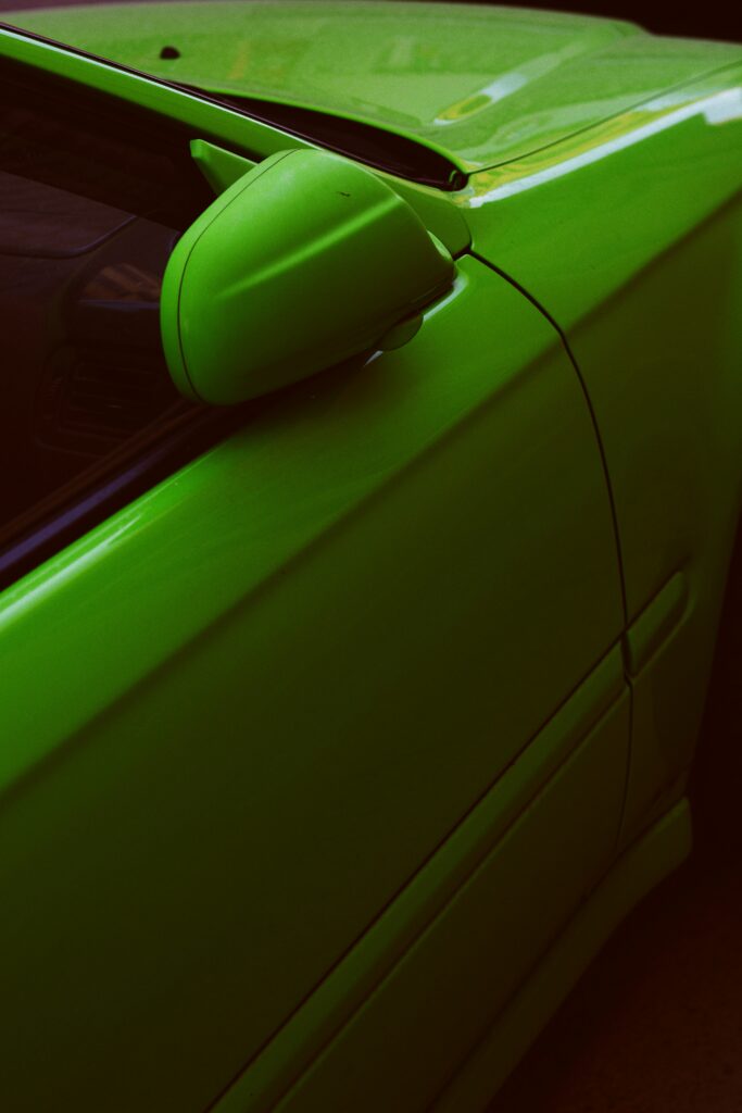 Sleek Green Car Close-Up: Vibrant Design & Glossy Finish Wallpaper