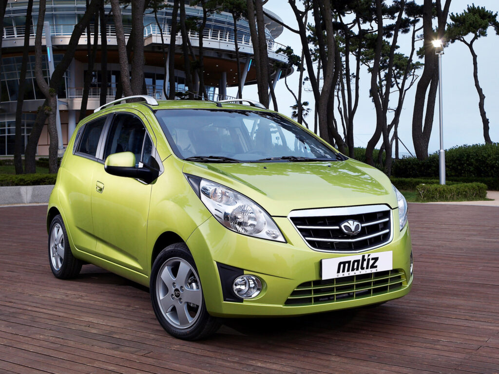 Vibrant Green Daewoo Matiz: Stylish Side View on Rustic Platform Wallpaper