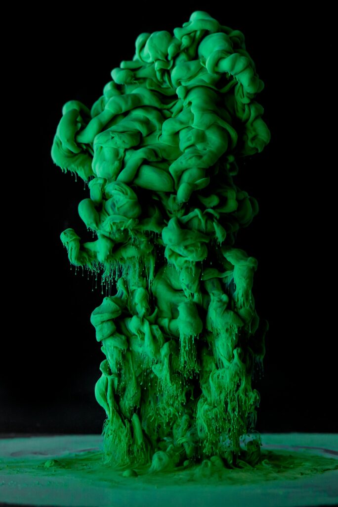 Vibrant Green Ink Swirl on Black Background - Striking Abstract Wallpaper