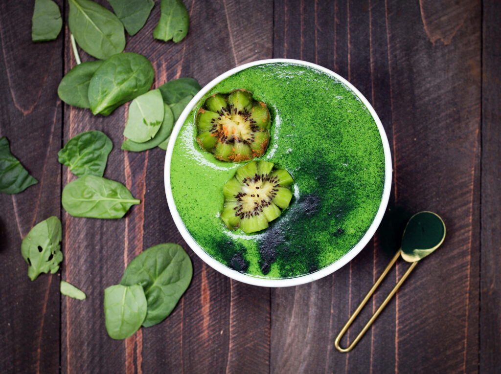 Vibrant Green Smoothie Bowl with Kiwi & Spinach on Wooden Table Background Wallpaper