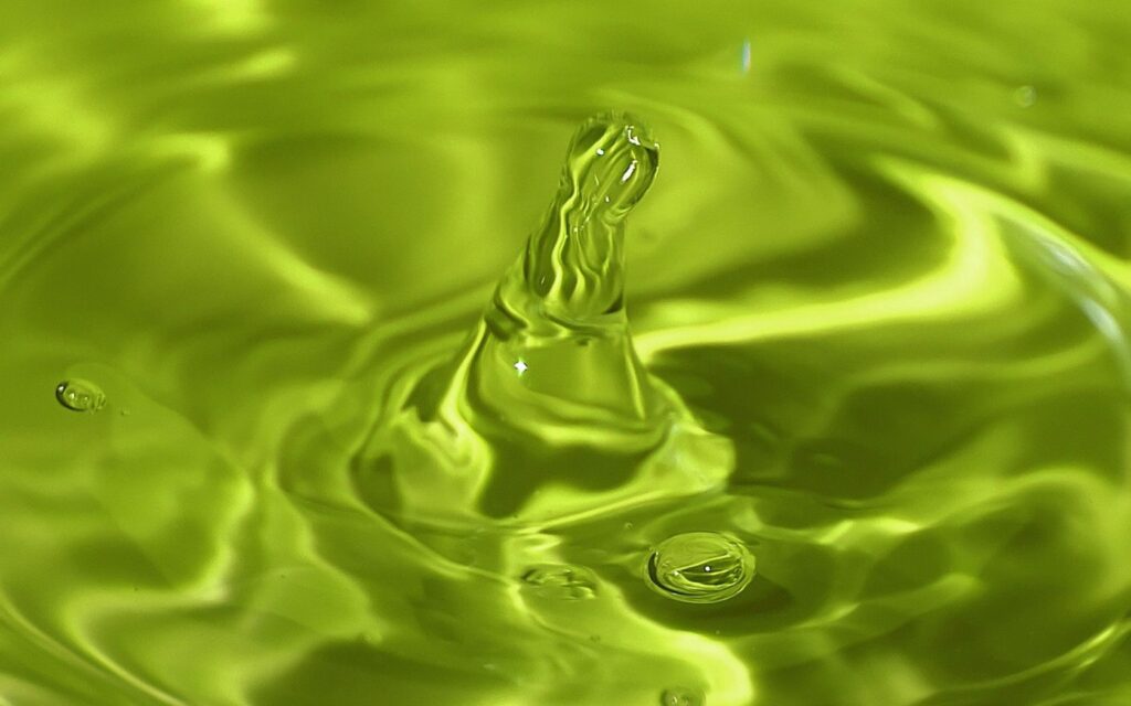 Vibrant Green Wallpaper: Water Droplet Splash with Rippling Waves