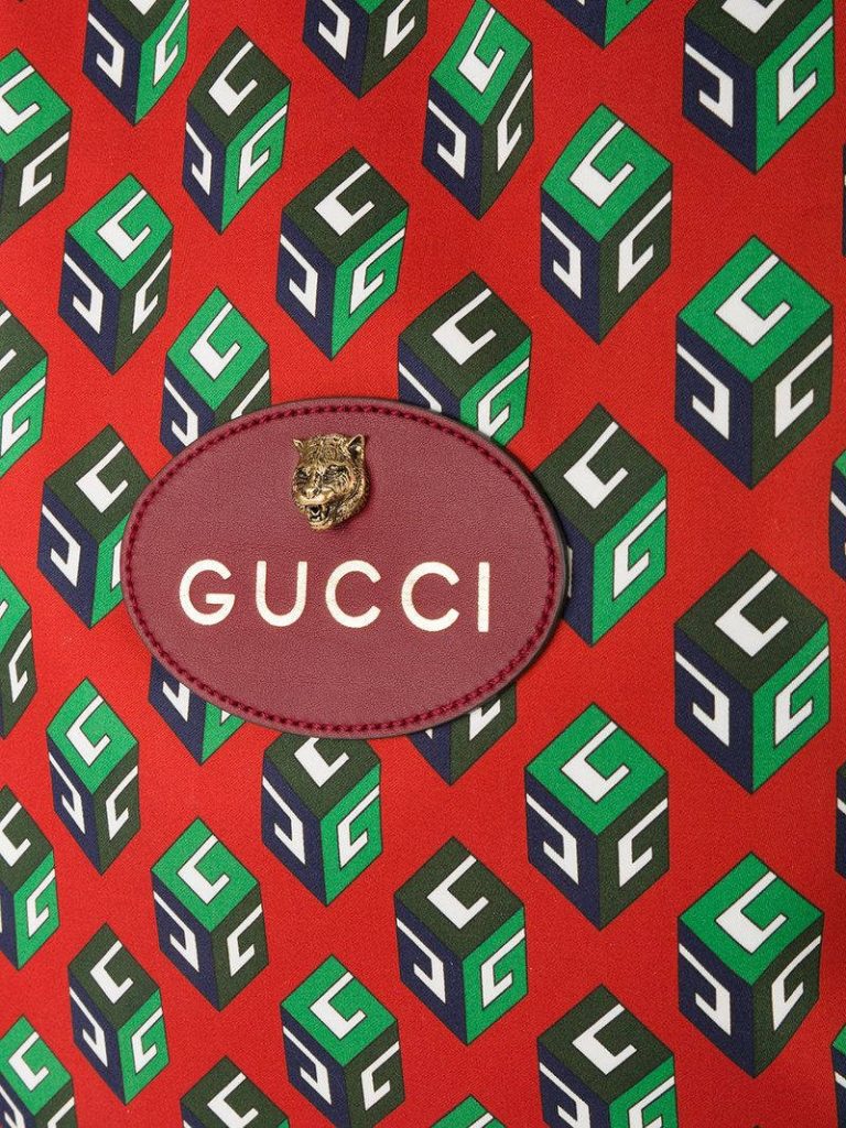Vibrant Gucci wallpaper with red background geometric cube pattern maroon logo patch golden feline head emblem