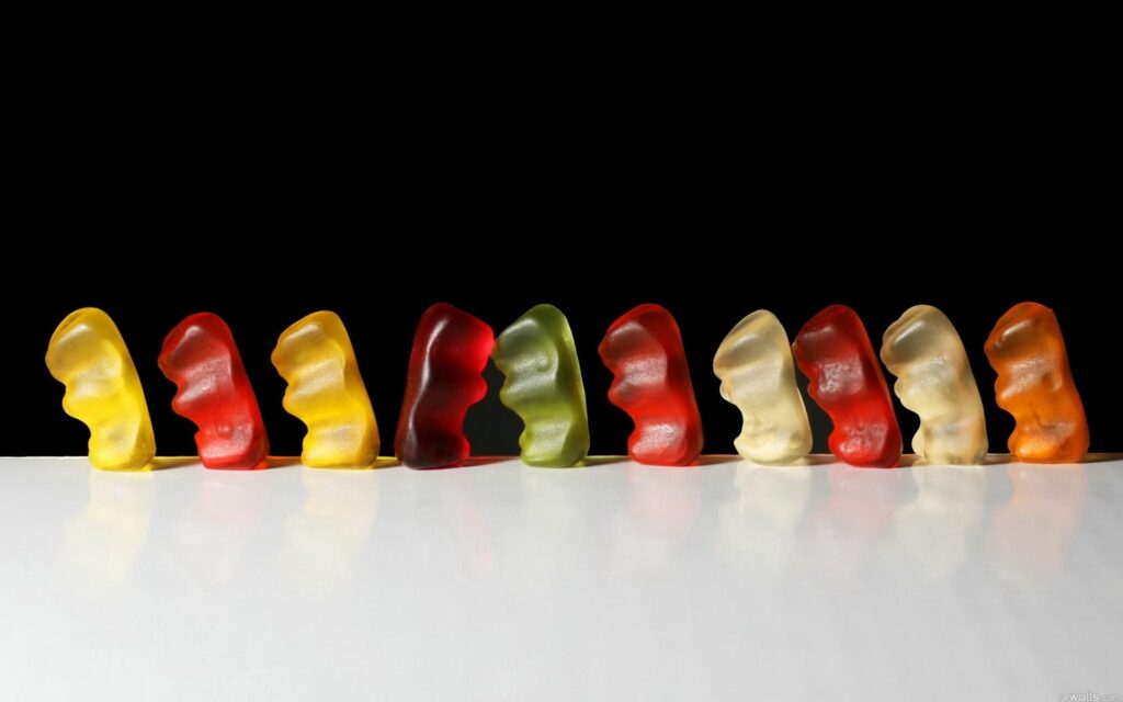 Vibrant Gummy Candy Wallpaper: Colorful Shapes Against a Bold Background