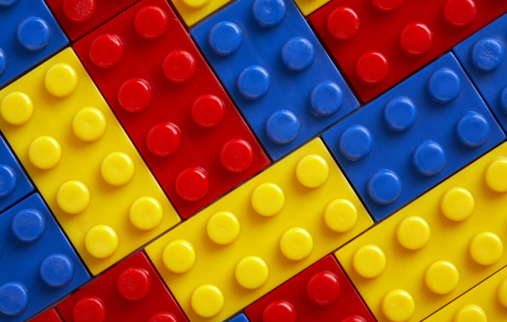 Vibrant close-up of red yellow and blue Lego bricks forming a colorful geometric pattern wallpaper