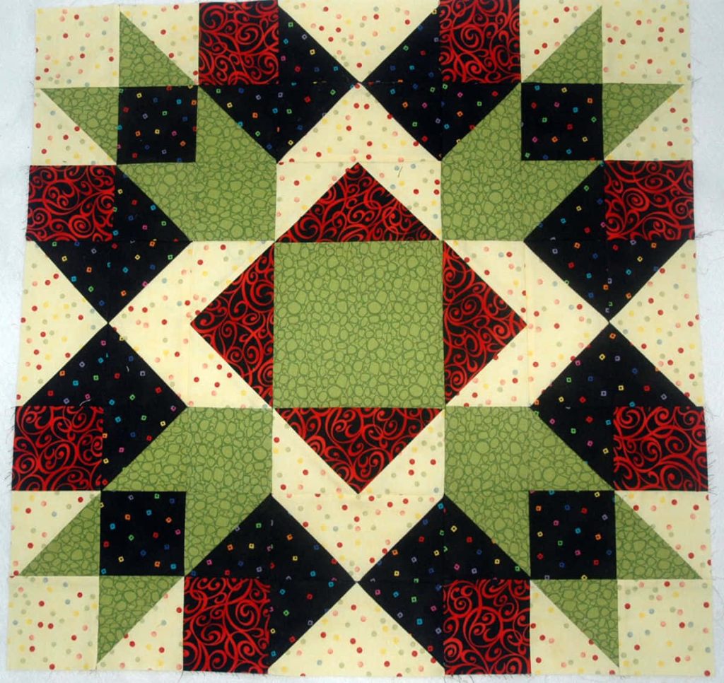 Handcrafted quilt block with red swirls green squares black colorful dots cream background patchwork Wallpaper